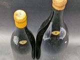 two bottles of wine are sitting on a gray surface