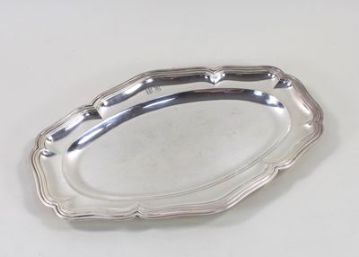 une assiette ancienne en argent posée sur un fond blanc