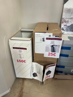 deux cartons et un réfrigérateur dans un coin de la pièce