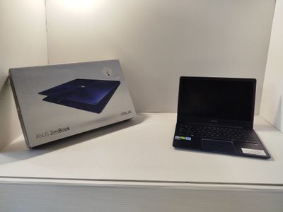 a laptop sitting on a white table next to a box