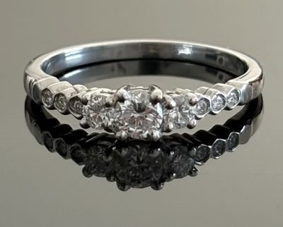 a close up of a diamond ring on a reflective surface