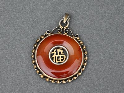 un gros plan d'un pendentif orné d'un symbole chinois