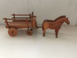 pair of wooden toy horses pulling a wagon with a wooden horse