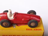 a red toy car with a man in it on a yellow box