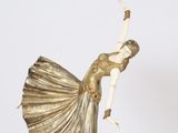 sculpture of a woman in a gold dress on a marble base