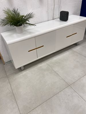 un buffet blanc à deux portes, surmonté d'une plante