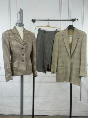 two suits on display on a rack in a room