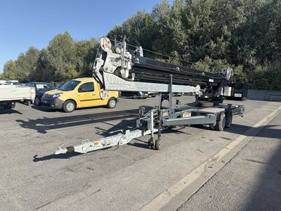 a crane that is sitting on a trailer in the parking lot