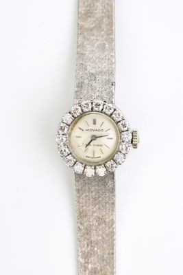 un gros plan d'une montre sur une surface blanche avec un fond blanc