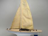 a small model sailboat on a stand on a white surface