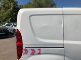 a white van parked in a parking lot with other cars in the background