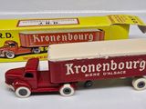 a toy truck that is sitting next to a box of kronenhburg beer