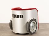 a silver and red chair with wheels on a concrete floor