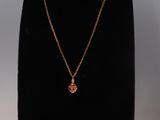 un collier en or orné d'une pierre rouge sur un mannequin noir