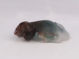 a figurine of a dog laying down on a white surface