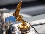 the hood ornament of a vintage car with a golden winged emblem
