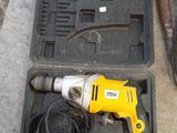 a yellow drill in a black case on the ground