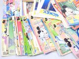 a pile of mickey mouse comic books on a table