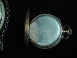 a silver pocket watch with a chain around it