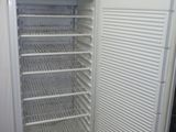 un réfrigérateur blanc dont la porte est ouverte, dans une pièce