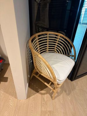 a wicker chair in the corner of a room