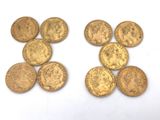 several gold coins are arranged in a row on a white surface