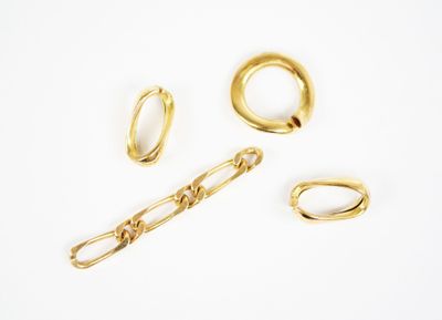 three gold rings and a chain on a white surface