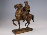 statue of a man riding a horse on a wooden base