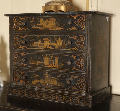 a small chest of drawers with a clock on top of it