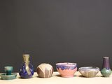 several vases and bowls are lined up on a table