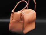 a brown leather handbag on a black background