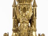 a gold clock with a statue on top of it