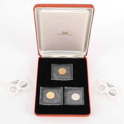 deux pièces d'or et d'argent dans une boîte rouge posée sur une surface blanche