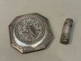 a small silver object next to a lighter on a table
