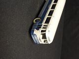 a toy bus that is sitting on a black surface