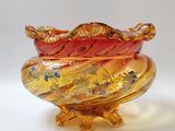 un bol en verre orné d'un motif doré et rouge