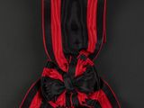 a red and black ribbon with a black bow on a black background