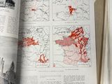 a book open to a map and a hand holding it