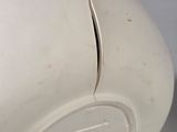 a white vase that has a hole in the top of it