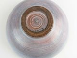 a brown and blue bowl on a white surface
