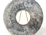 une sculpture en pierre représentant un objet circulaire posé sur un socle