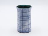 un vase bleu orné d'un motif en noir et blanc