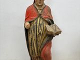 une statue représentant un homme tenant un livre entre ses mains