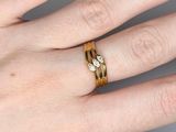 a woman ' s hand with a gold ring on it