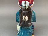 a figurine of a man with a hat and a suitcase