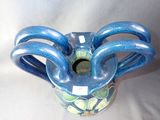 a blue and green vase that is sitting on a white surface