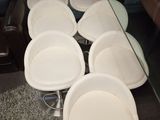 six white chairs and a glass table in a living room