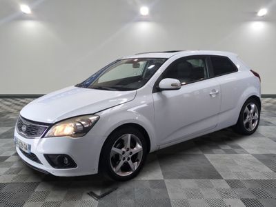 la voiture blanche est garée sur un sol en damier dans le garage