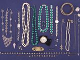 many necklaces and bracelets laid out on a blue surface