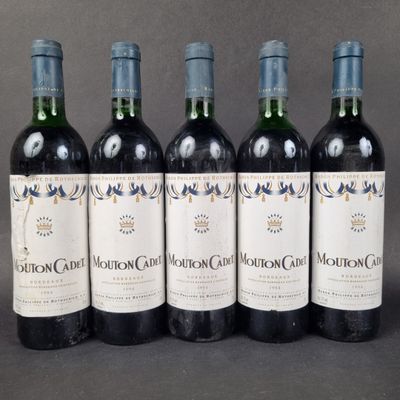four bottles of wine are lined up in a row